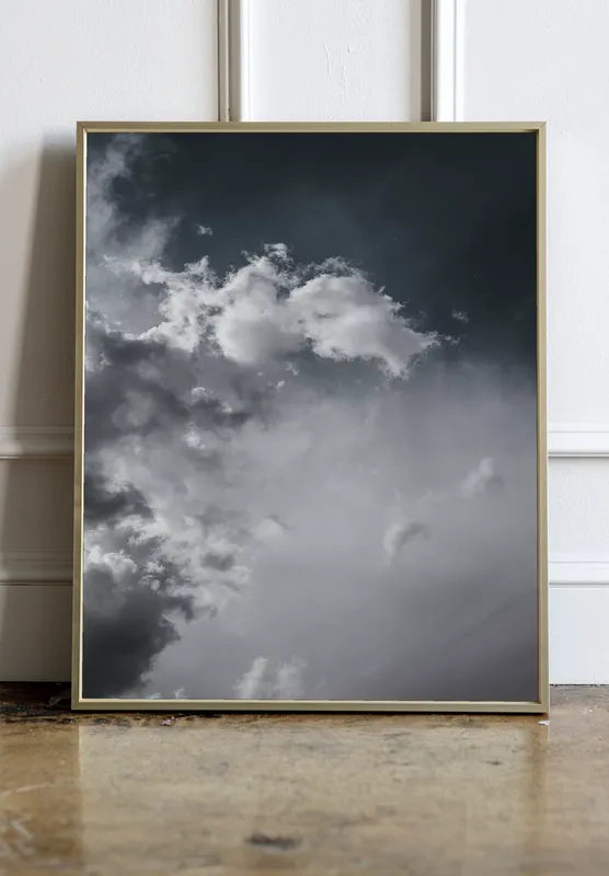 Постер «Облачное небо» над диваном в гостиной