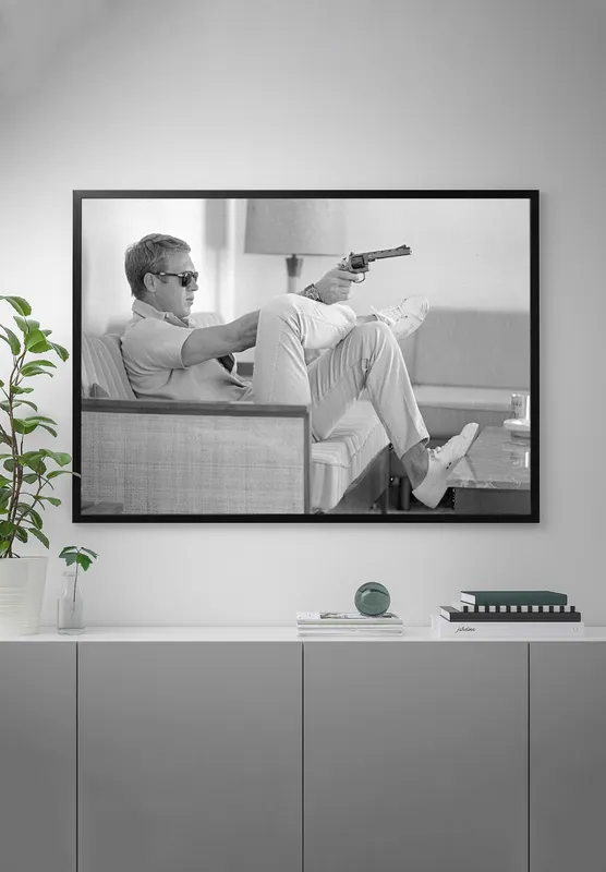 Постер «Стив Маккуин с пистолетом» над диваном в гостиной