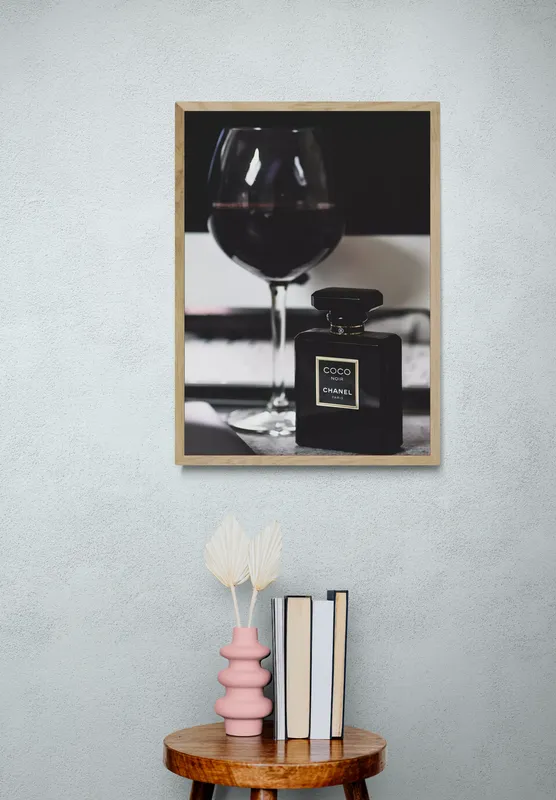 Постер «Рекламный постер духов Chanel noir» над диваном в гостиной