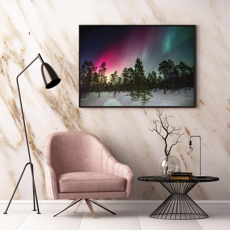 Постер «Северное сияние над лесом» над диваном в гостиной
