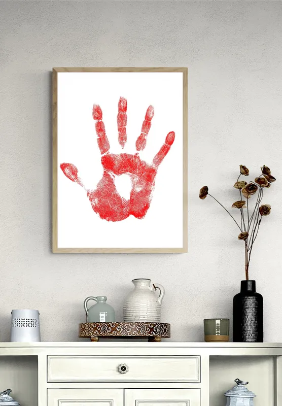 Постер «Отпечаток руки» над диваном в гостиной